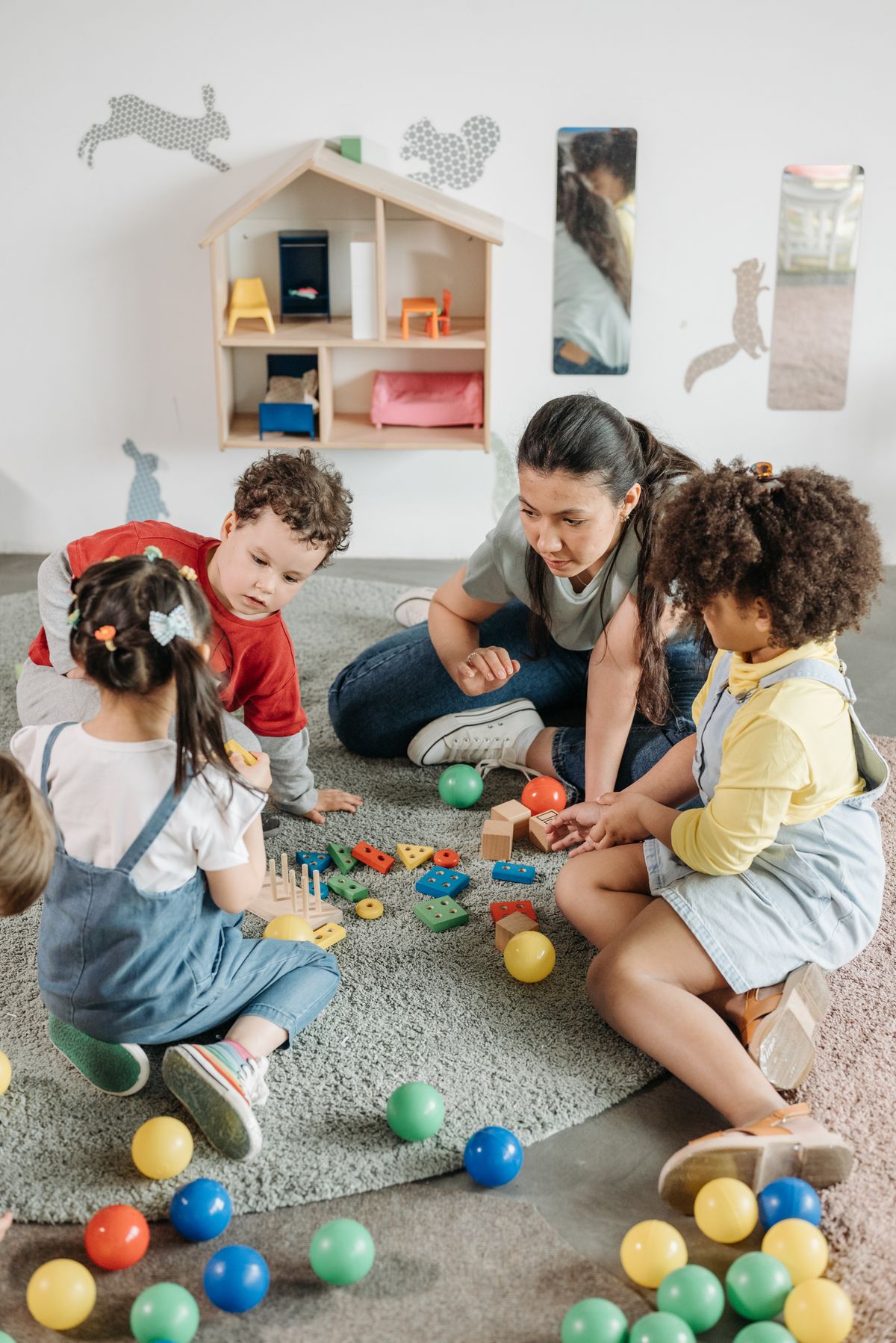 Toddler in the Little Lotus playgroup class exploring learning materials with a teacher