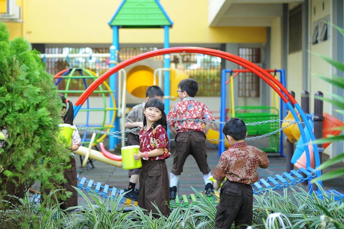 Nursery children at Little Lotus preschool playing and learning together outdoors