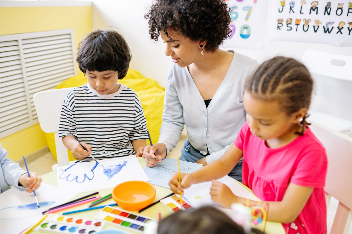 Child painting with bright colours in the Little Lotus creative studio