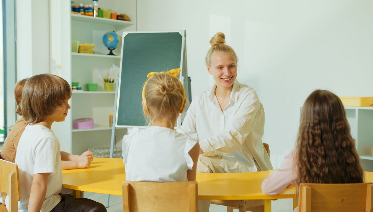 Teacher engaging with preschool children in a colourful classroom at Little Lotus kindergarten