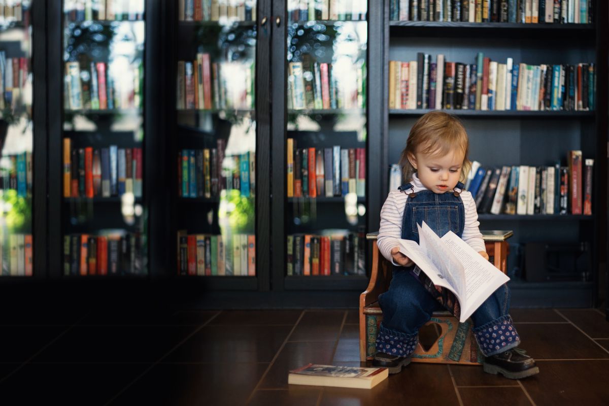 Preschooler reading a picture book in the Little Lotus mini library